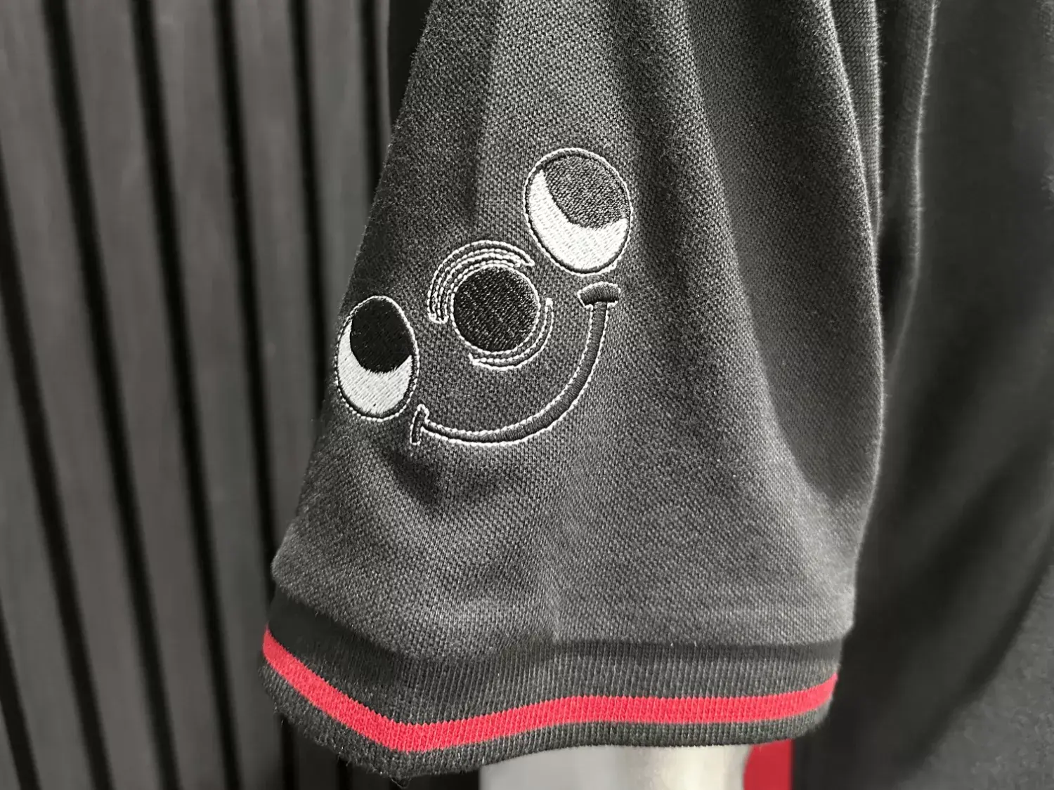 Close-up of custom embroidered logo on a branded polo shirt sleeve showcasing professional embroidery stitching.